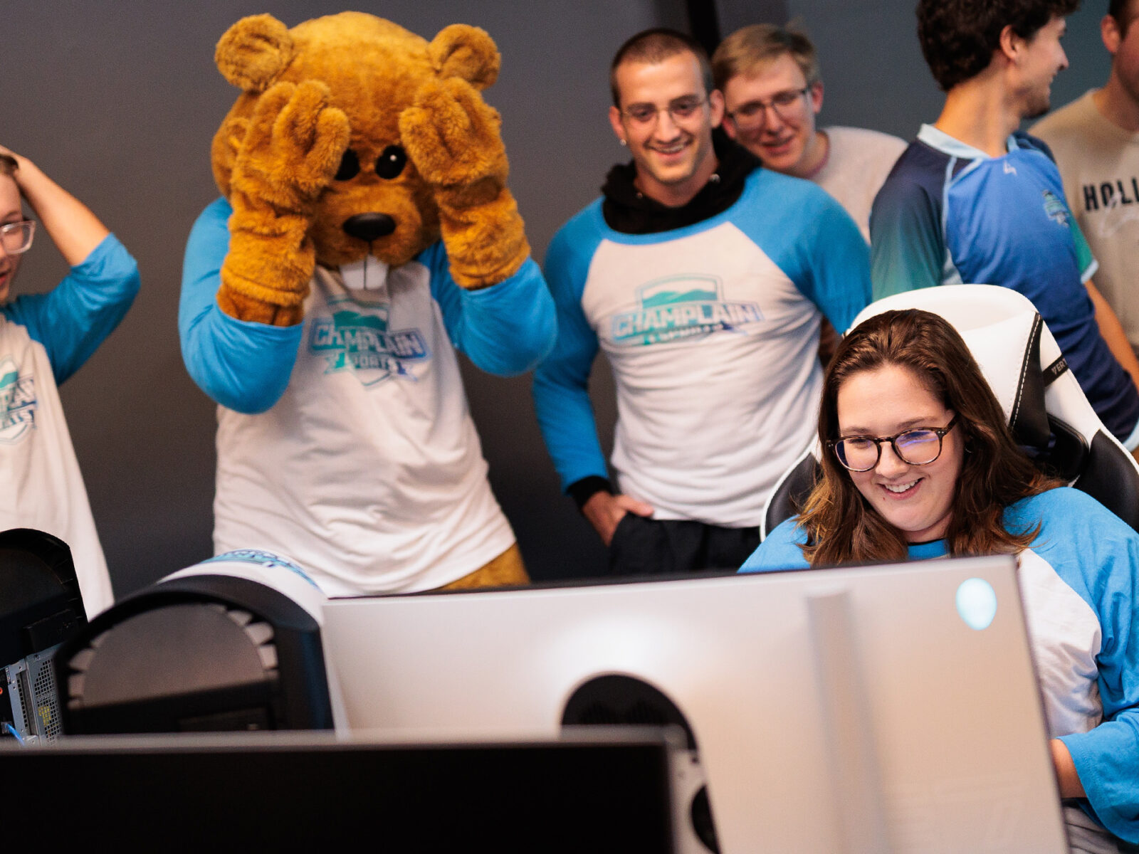 student competes at esports as others intensely watch the game play