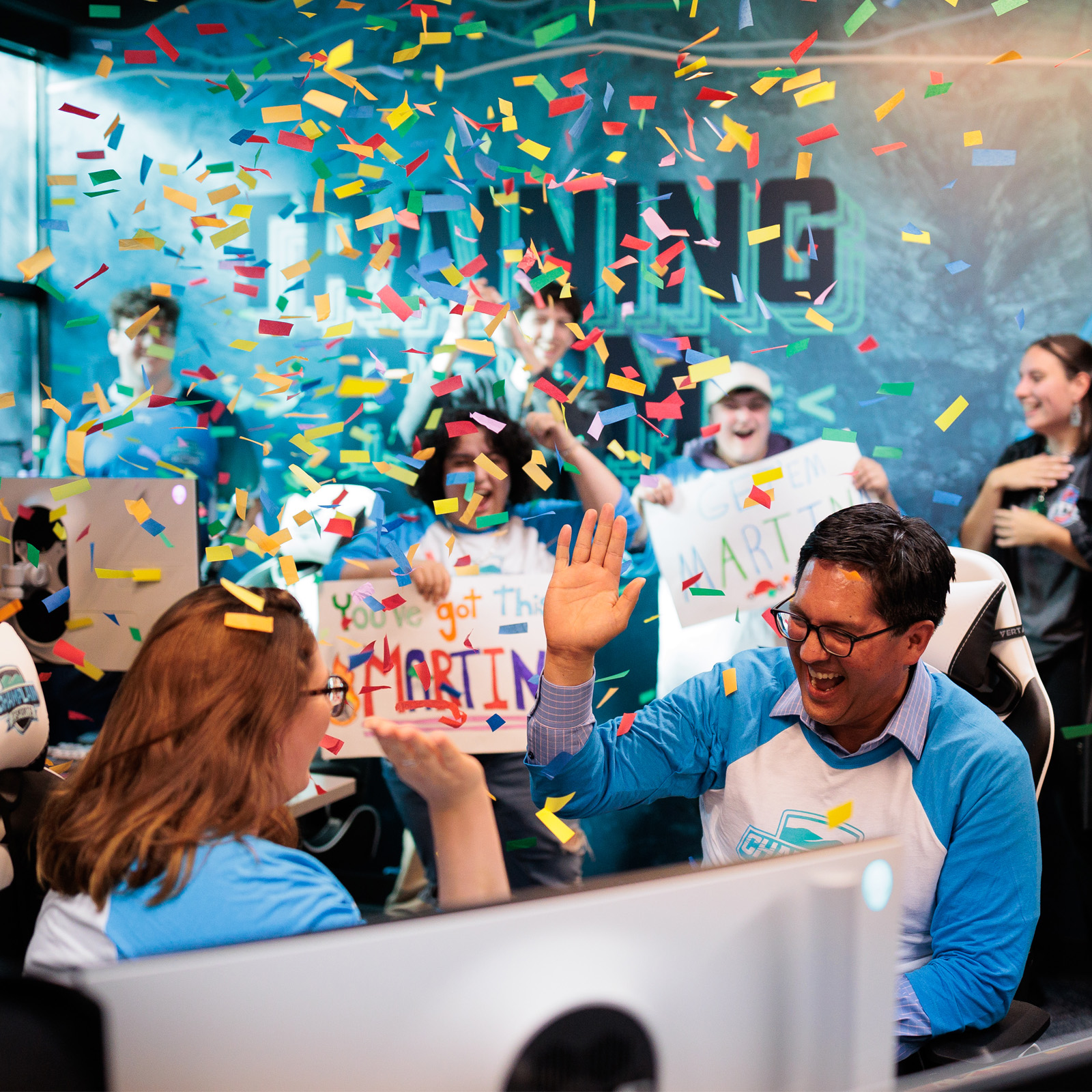 a celebration in the ESports arena; President Hernandez high-fives a student