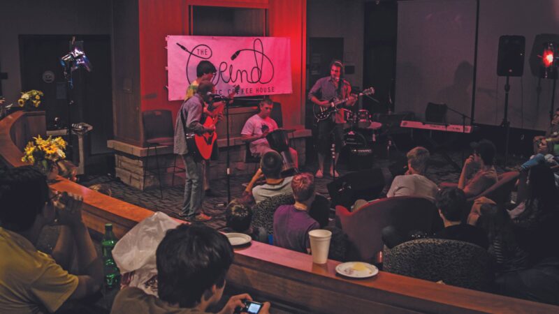 Students in fireside lounge preforming during The Grind with a red hue of light