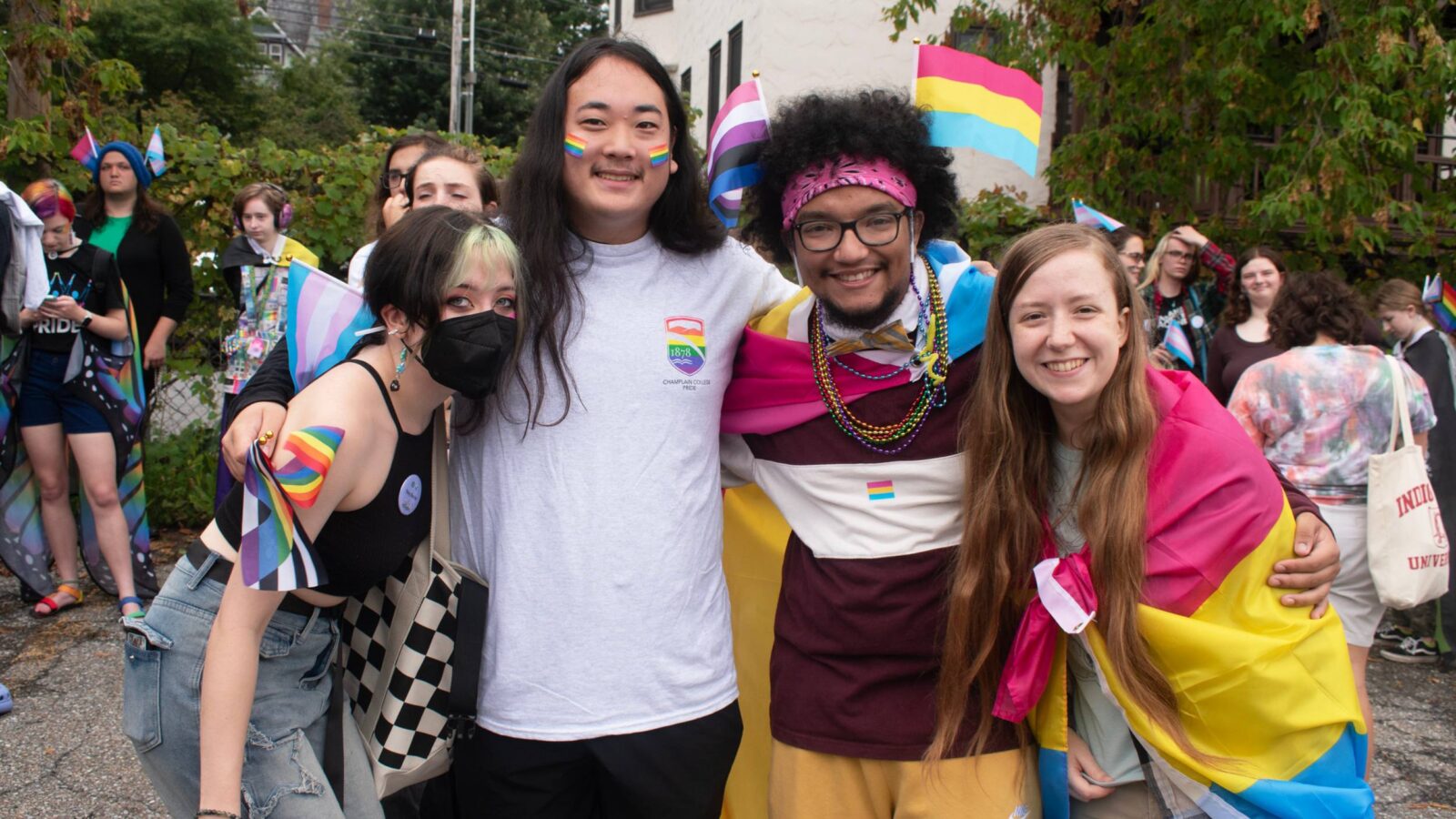 Group of students celebrating pride and posing with flags and face paint