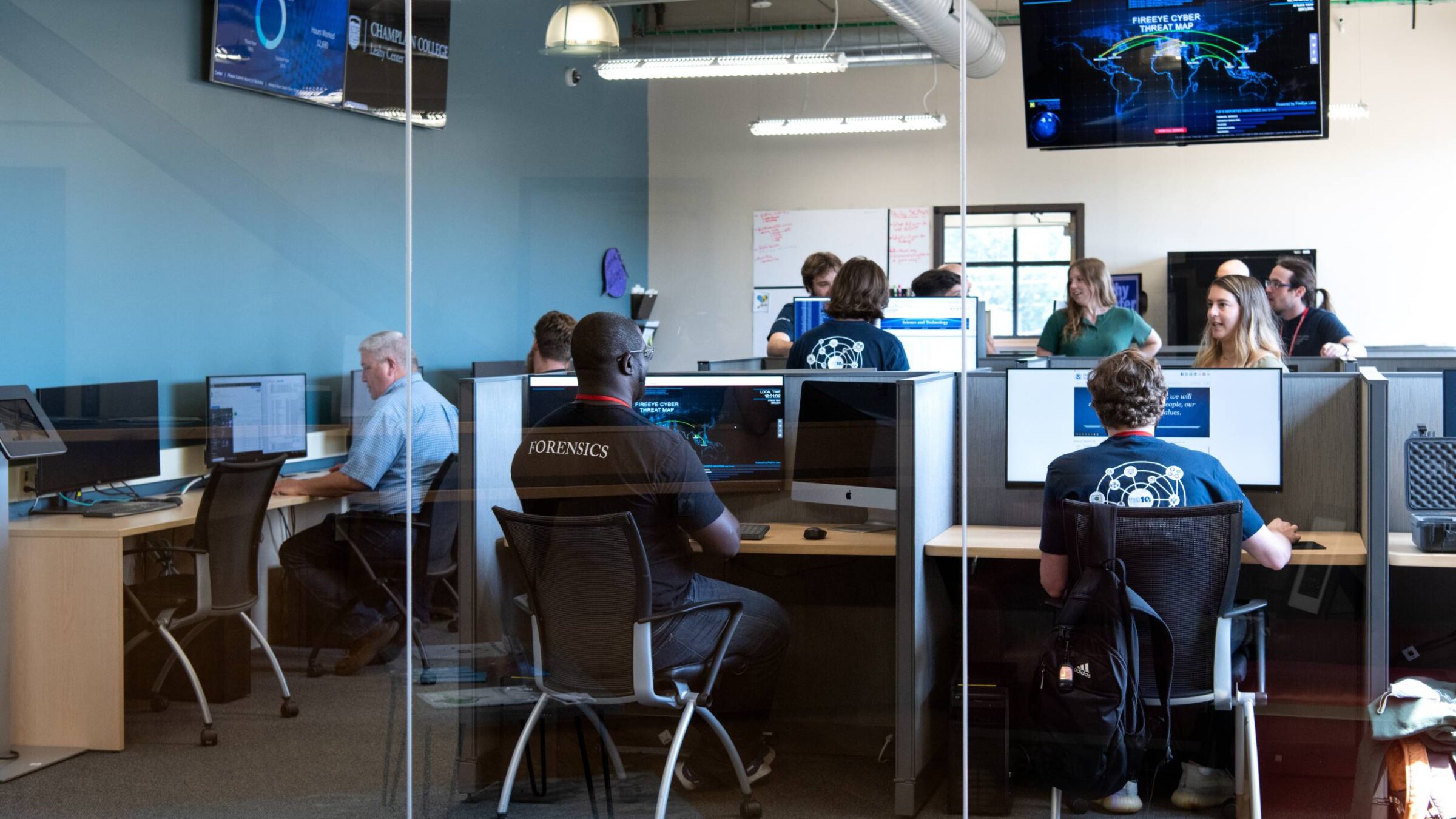 a photo of the leahy center with students and staff working on computers in cubicles