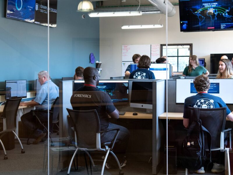 a photo of the leahy center with students and staff working on computers in cubicles