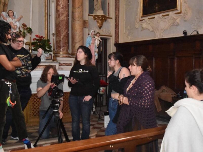 a group of filmmaking students setting up for a shoot in a church