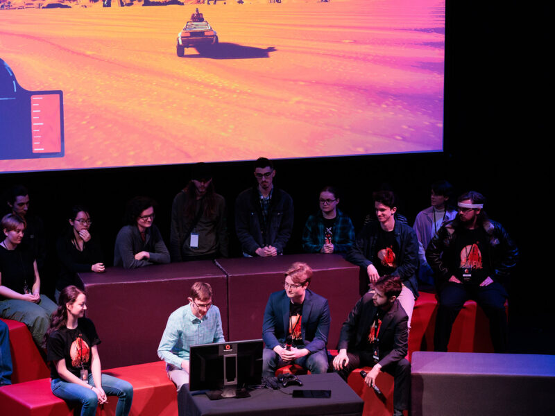 students presenting their finished game at the senior game show on stage in the auditorium
