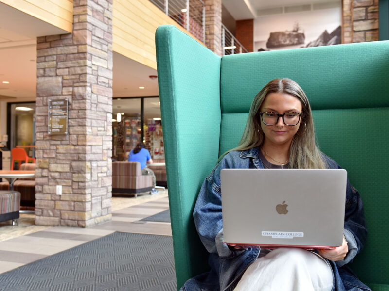 A student works on her laptop in the commuter lounge at Champlain Colllege.
